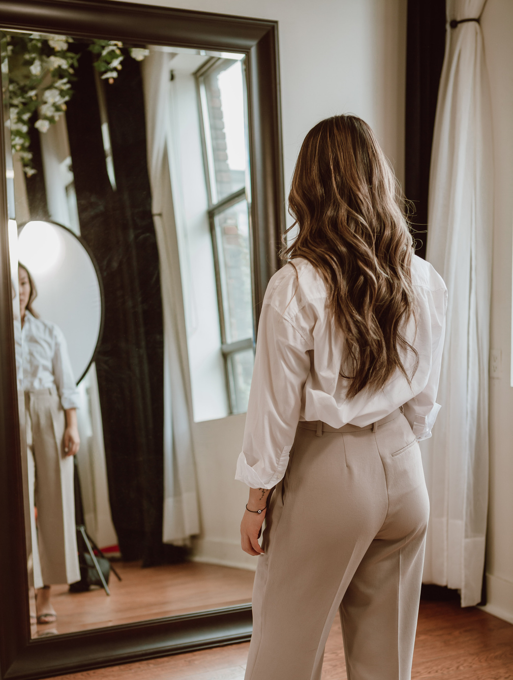 Elegant Woman Standing and Looking at the Mirror